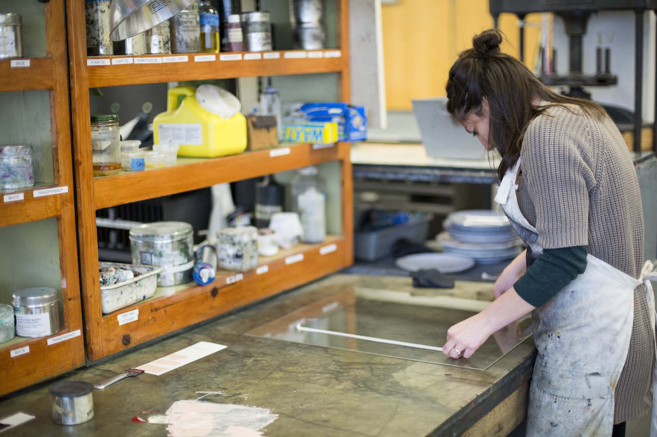 Student making art at a table